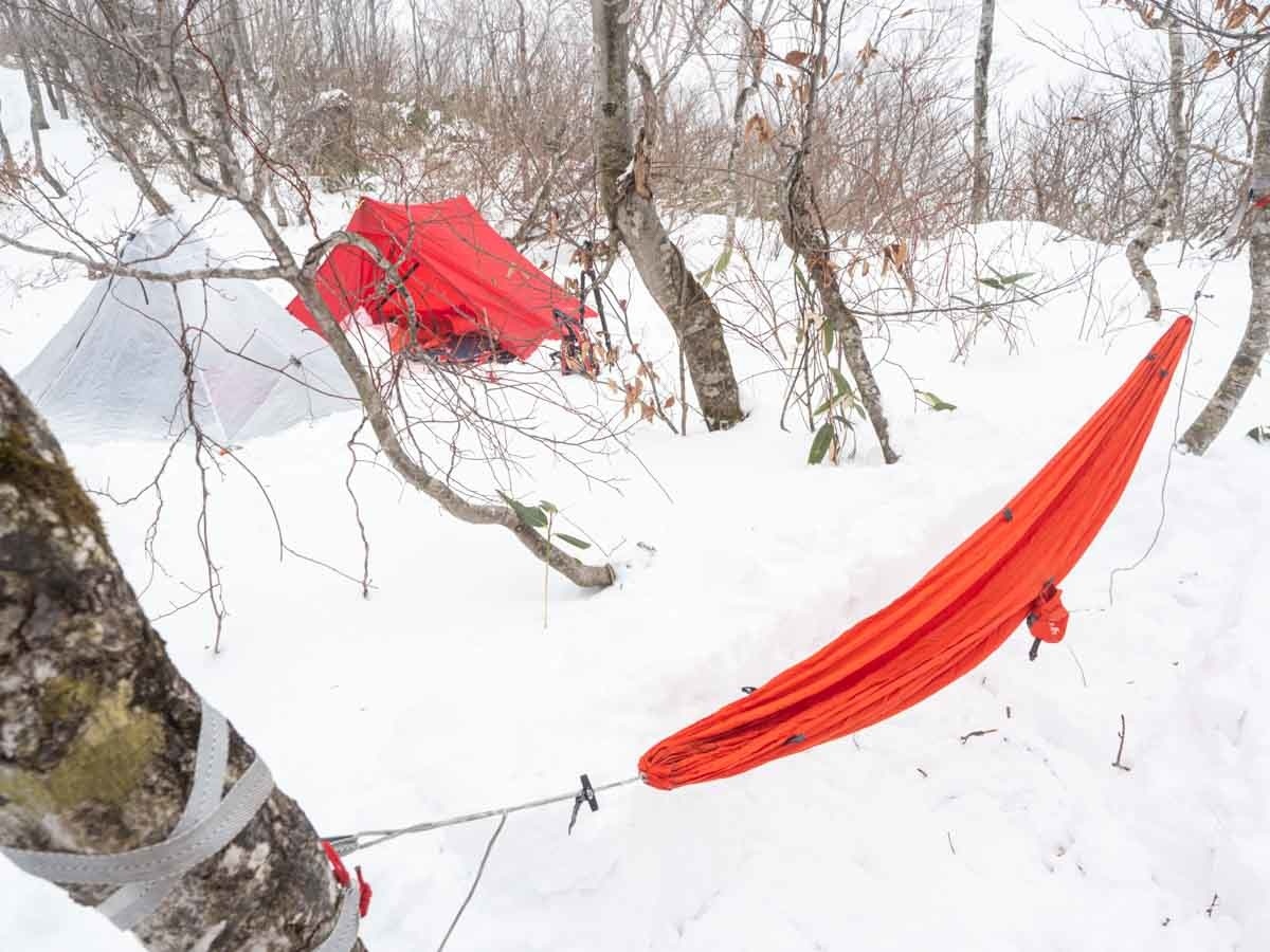 雪上にハンモックとテントを設営