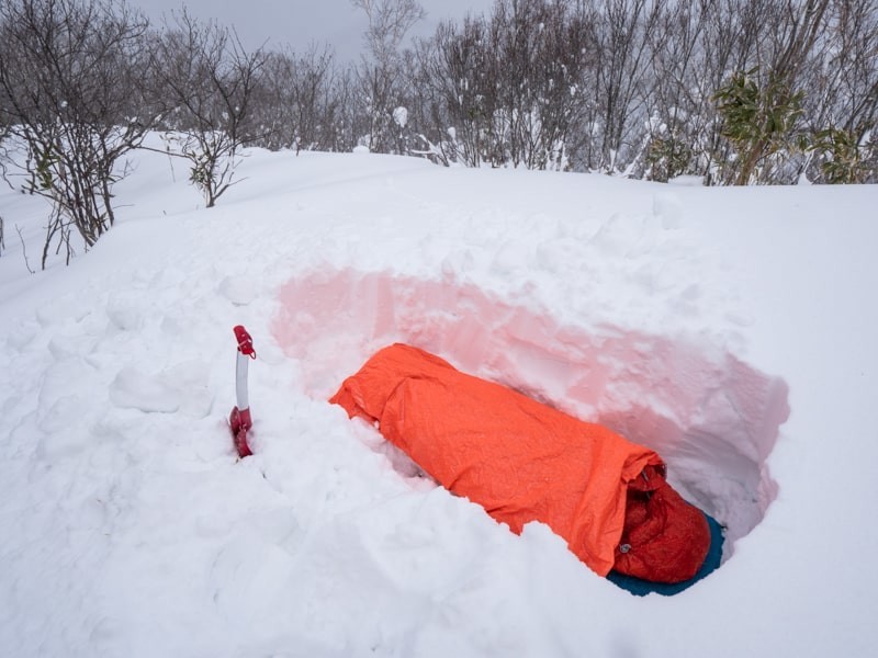 雪を掘って寝袋で寝る