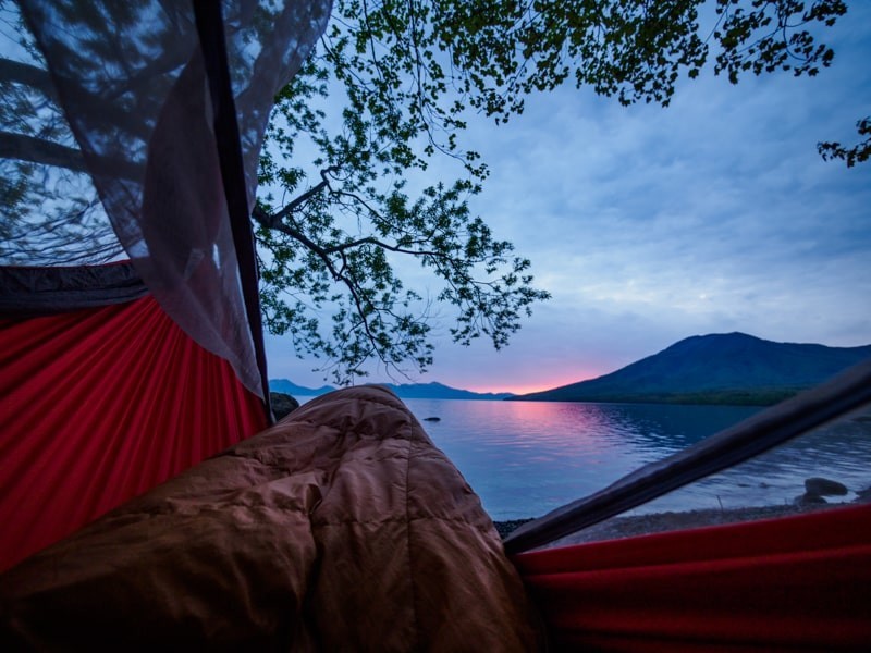 ハンモックの上で寝袋に入ったまま見る日の出前の湖