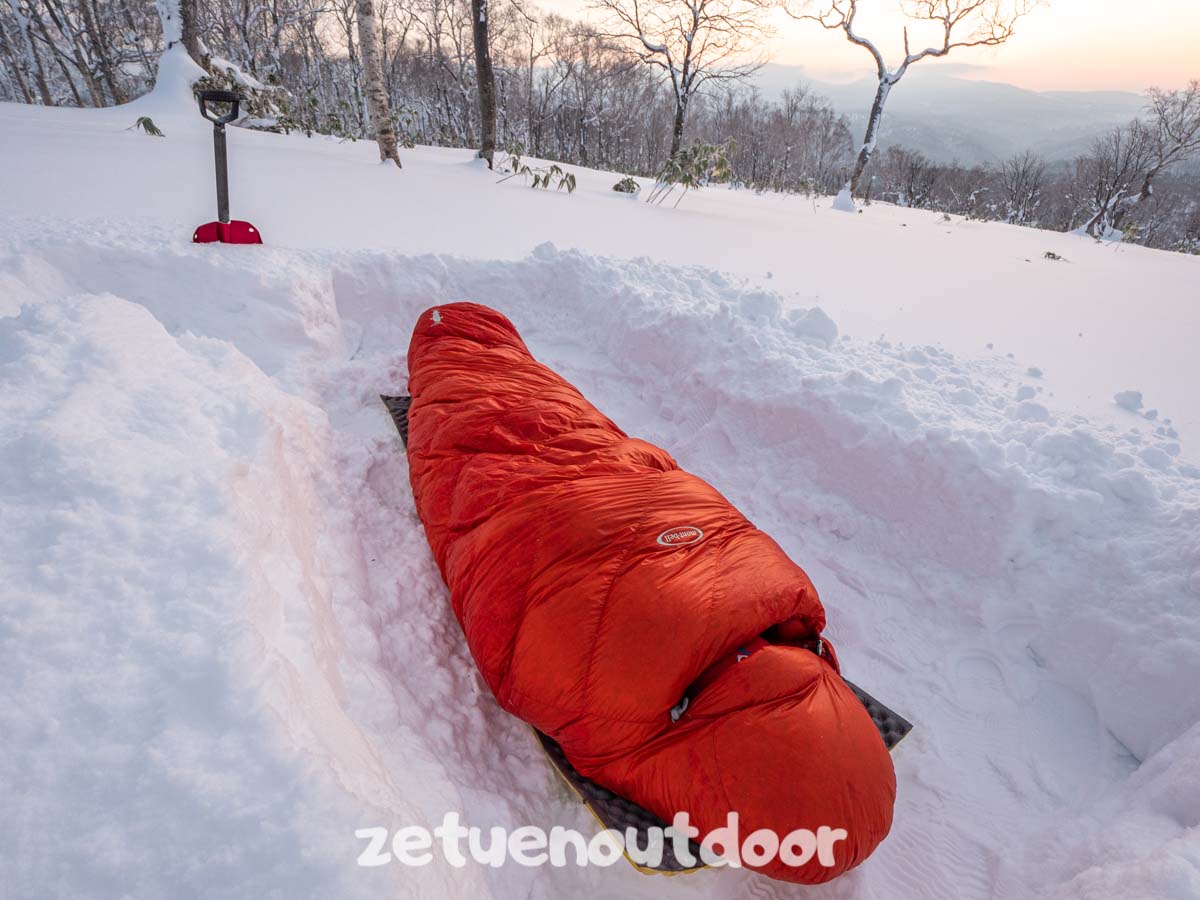 雪の上で寝袋で寝る