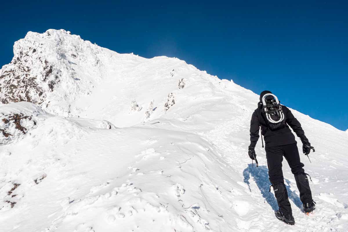 晴天の雪山を登る登山者