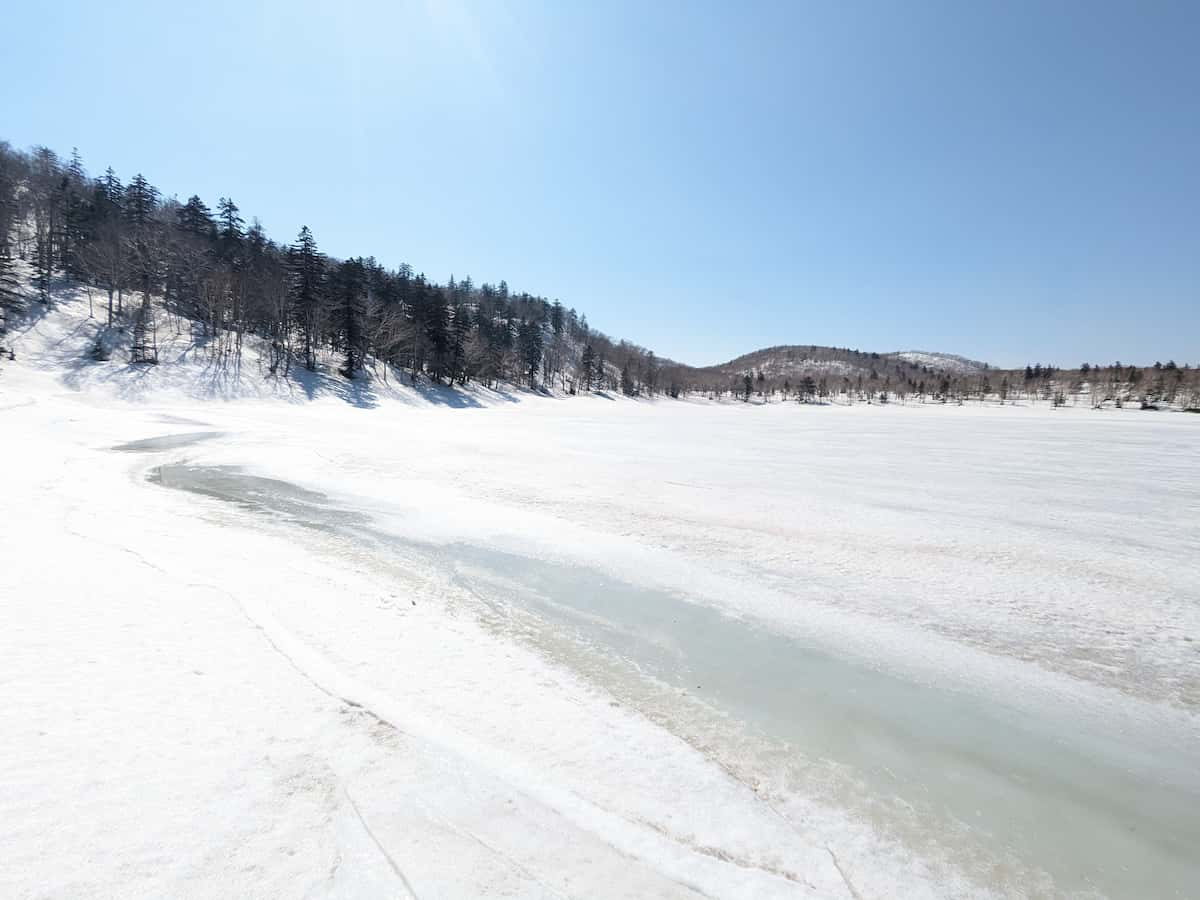 残雪の空沼岳の全面凍結した真簾沼